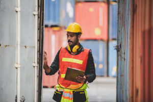 foreman or engineer are work in container shipping industry warehouse, logistic transport to import and export cargo at delivery storage port terminal, man are work to control a business box