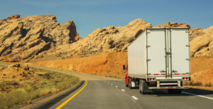 Modern Semi Truck Vehicle on Scenic Utah Highway. Rock Formations Landscape. American Transportation Industry Theme.